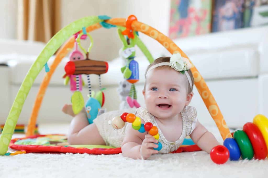 baby girl playing with a non-toxic toy gym