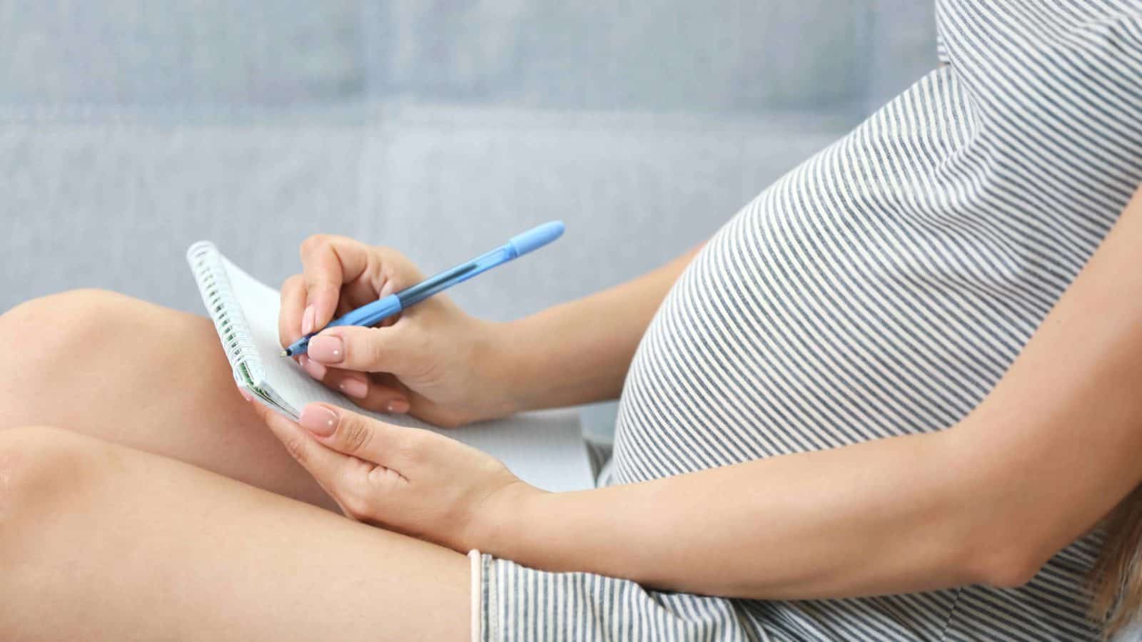 pregnant mom writing down her baby registry checklist