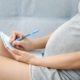 pregnant mom writing down her baby registry checklist