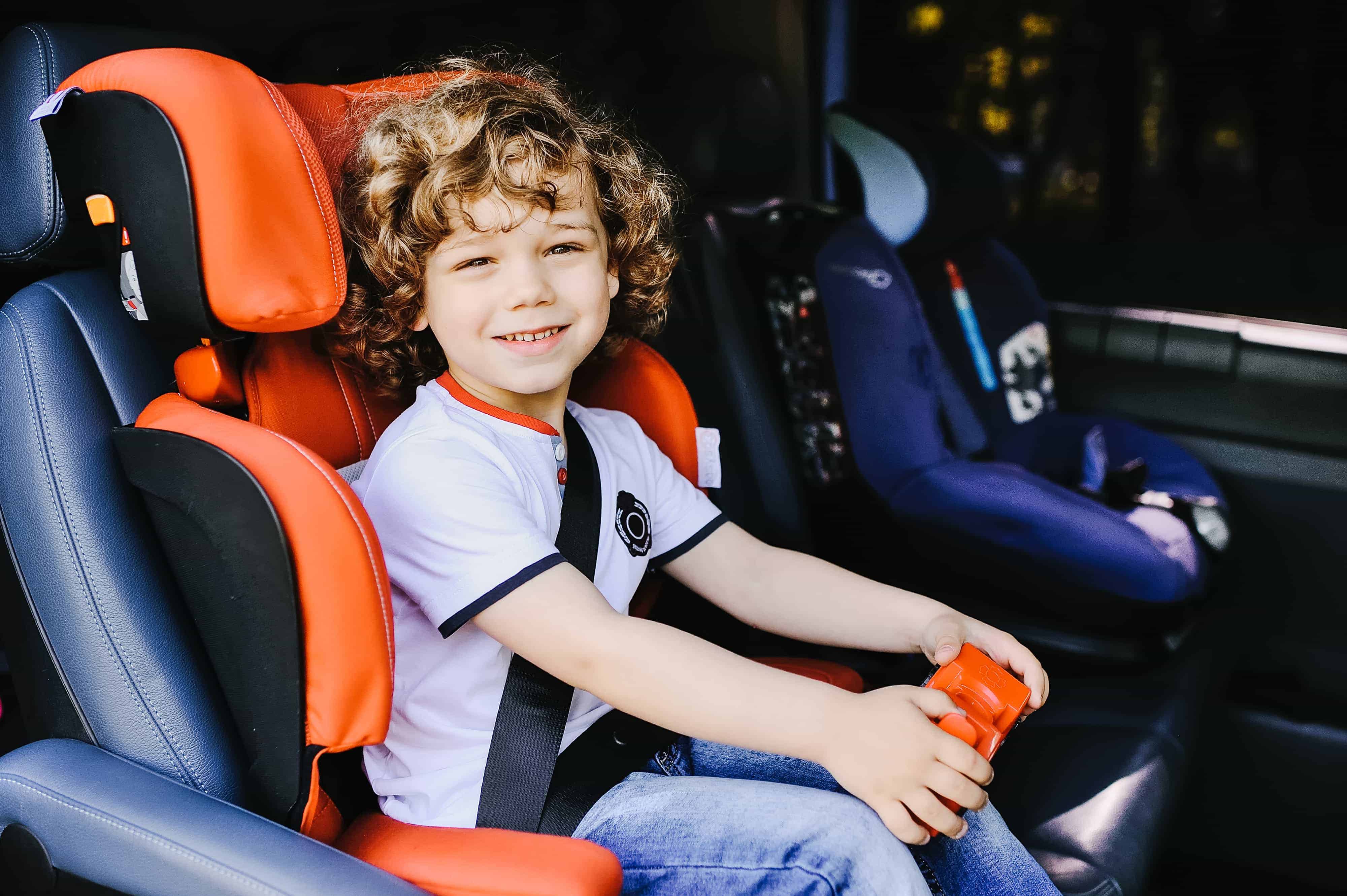 child in booster seat in car