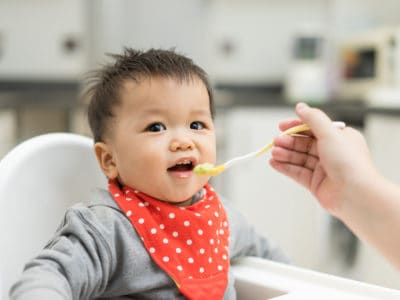 picture of baby being fed solid foods