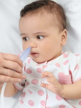 mom using nasal aspirator on baby to gently clear congestion