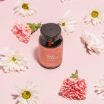bottle of biomeology mama probiotics surrounded by pink and white flowers
