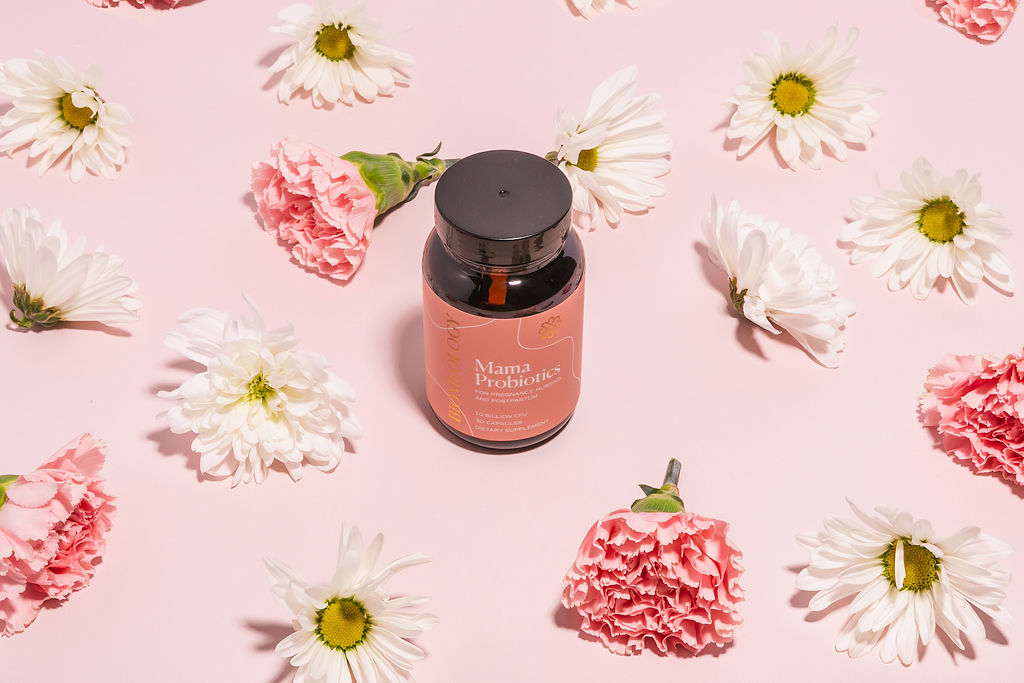 bottle of biomeology mama probiotics surrounded by pink and white flowers