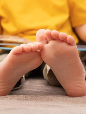 closeup of childs feet while he reads a book