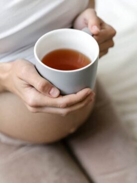 pregnant woman holding mug of red raspberry leaf tea