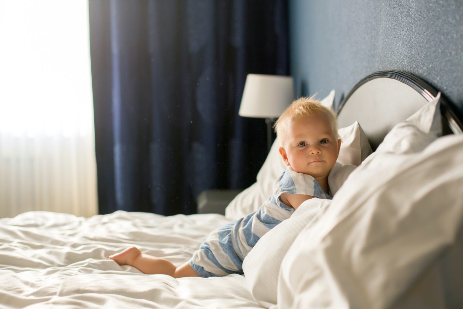 baby playing in bed at hotel or Airbnb