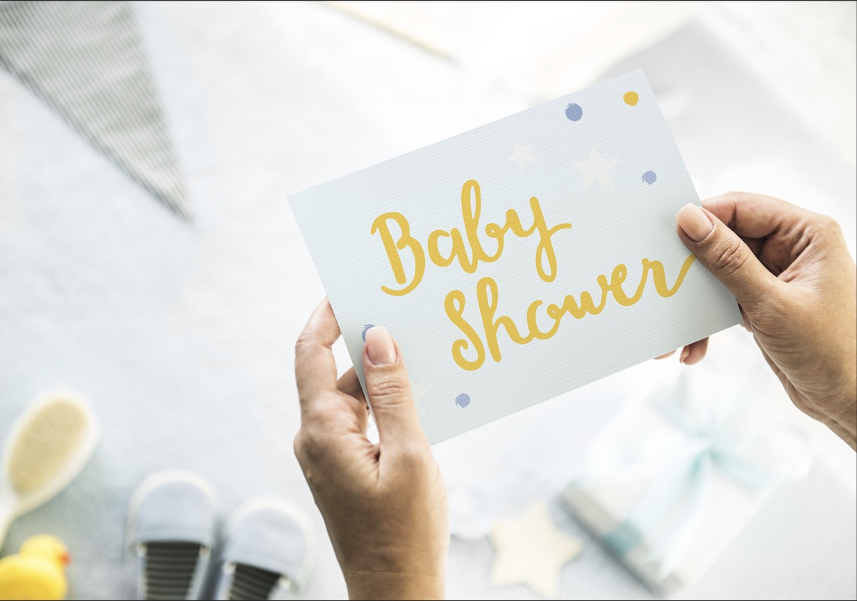 closeup of woman's hands holding baby shower invitation