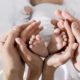 closeup of mom and dad's hands holding newborn baby's feet in a loving way