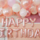 birthday party backdrop — pink and white balloons and rose gold happy birthday baloons